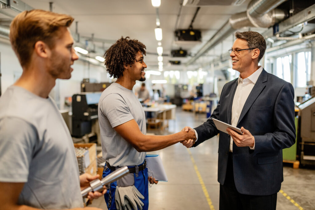 happy company manager shaking hands with african american steel worker.