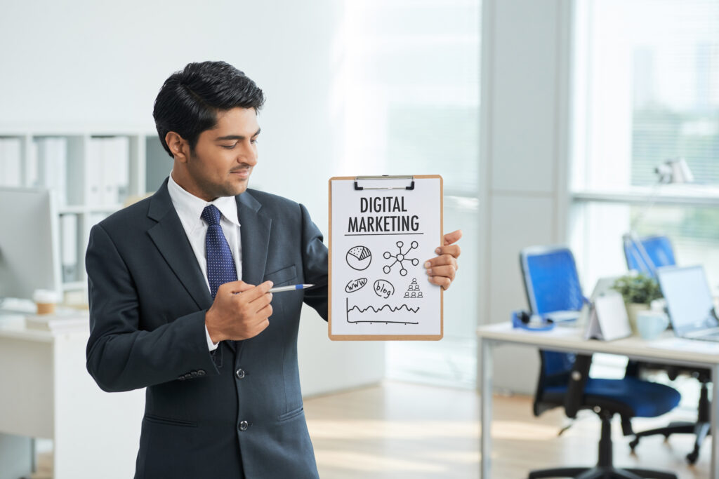 Man Suit Standing Office With Clipboard Pointing Poster With Words 1024x683